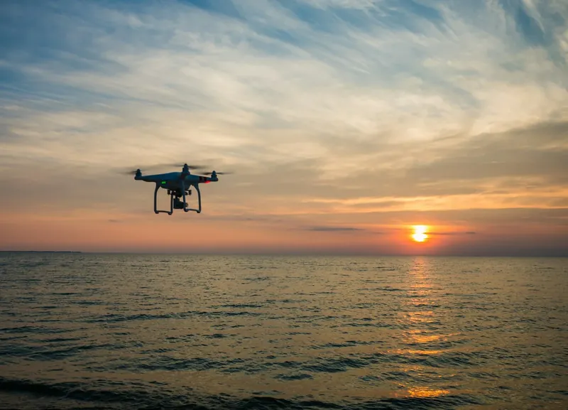 Drone agrícola em pleno voo, pulverizando uma lavoura com precisão, demonstrando a tecnologia inovadora utilizada na agricultura moderna para otimizar o trabalho e aumentar a produtividade.